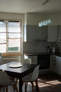 纳沙泰尔Maujobia 31的厨房配有黑色的桌子、椅子、桌子和桌子。