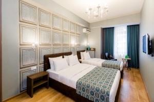 第比利斯Hotel Diamond的酒店客房设有两张床和吊灯。