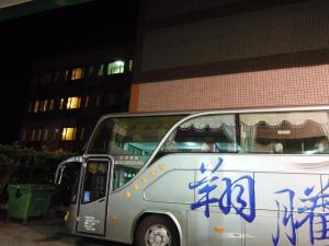 Xiluo三好商务汽车旅馆的一辆白色的公共汽车,车身边有蓝色的文字