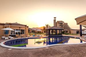 迪巴皇家海滩度假酒店的一个带凉亭的游泳池和一座建筑