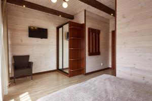 布克维Zlata的配有木墙、椅子和电视的客房