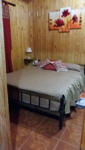 伊瓜苏港奥尔内罗山林小屋的卧室配有木墙内的一张床