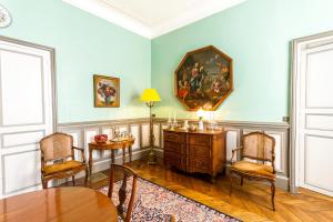 沙托鲁法萨迪住宿加早餐旅馆的用餐室配有桌椅和墙上的绘画作品