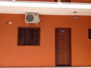 乌巴图巴Chalés Ubatuba 102 - P. Itaguá的橙色的墙壁,配有风扇和门