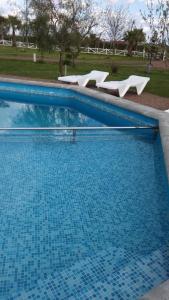 特玛斯德戴曼索勒露娜矿泉度假酒店的公园里一个带椅子的大型蓝色游泳池