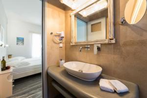 德里奥斯塔萨公寓酒店的一间带水槽和镜子的浴室以及一张床