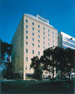 高松丽嘉高松泽斯特酒店的一座白色的大建筑,上面有标志