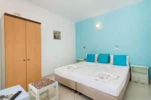 林都斯赛诺内斯林佐斯酒店的一间卧室配有一张带蓝色墙壁的大床