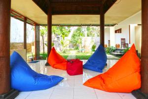 库塔Taste of Bali Hostel的四个五彩缤纷的枕头坐在房子的地板上