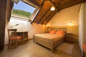 伊萨尔苏Hotel Rural Besaro - Selva de Irati的一间卧室配有一张床、一张书桌和一个窗户。