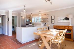 开普敦33 Strawberry Lane - Studio and Cottage的厨房配有木桌和椅子