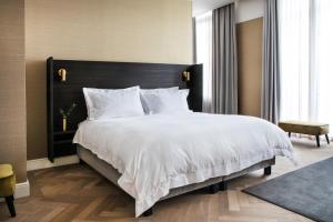 根特Pillows Grand Boutique Hotel Reylof Ghent的一间卧室配有一张白色大床和黑色床头板