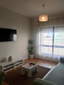马亚Destiny Oporto的带沙发、电视和桌子的客厅