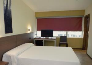 阿尔特萨苏艾泽雷酒店的一间卧室配有一张床和一张带电脑的书桌