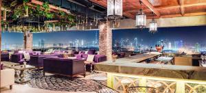 迪拜克里克高地凯悦公寓式酒店的一间设有紫色椅子的餐厅,享有城市美景