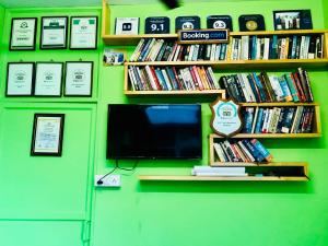 科钦巴斯蒂安寄宿家庭旅馆的绿色墙壁上的电视,带书籍