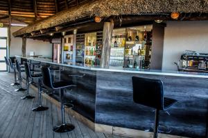 姆巴巴内Sibebe Resort的酒吧,酒吧有一排黑酒吧凳