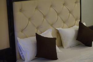 伯杰默里Hotel Khalsa -Lake View的一张带白色枕头的床和一个大床头板