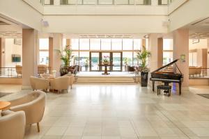 泰恩河畔纽卡斯尔国敦纽卡尔斯酒店的大堂设有钢琴、桌子和椅子。
