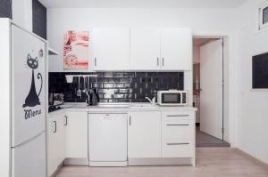 贝纳尔马德纳16 Benal Acogedor y en 1ª linea的白色的厨房配有冰箱和微波炉。