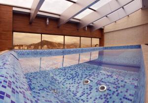 科恰班巴Apart Hotel Selenza的蓝色瓷砖建筑中的一个大型游泳池