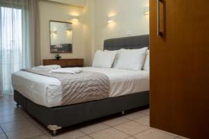 基萨莫斯格拉姆沃萨湾公寓式酒店的卧室配有一张带白色床单和枕头的大床。