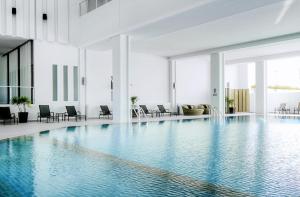 罗勇经典凯蜜欧酒店&酒店式公寓，罗勇府的一座带椅子的大型游泳池