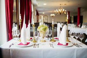 巴德马斯考福斯特普科勒公园库尔图尔酒店的一张桌子,上面有白色的桌布,连带餐巾和酒杯