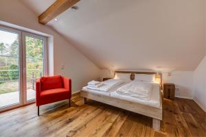 VogtFerienappartements Tor zum Allgäu的一间卧室配有一张床和一张红色椅子