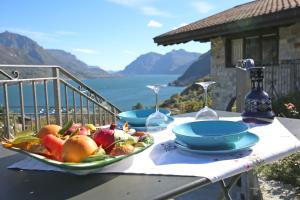 贝拉吉奥ALBA e TRAMONTO Appartamenti vista lago的一张桌子,上面放有一盘水果和酒杯