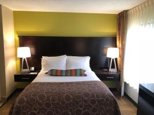 大急流城肯特伍德拉皮兹住桥套房大酒店的酒店客房设有一张大床和两盏灯