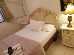 埃拉特Thai villa eilat - וילה תאי אילת的一间卧室配有一张带金色床头板和灯的床