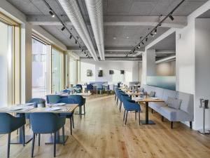 黑林山区圣格奥尔根Hotel Federwerk的一间配备有桌子和蓝色椅子的用餐室