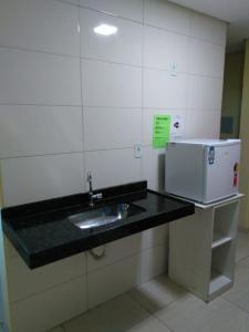迪维诺波利斯Pousada Elita的厨房柜台设有水槽和微波炉