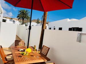 纳萨雷特Canaryislandshost l Lovely Lanzarote的庭院里配有一张带红伞的木桌