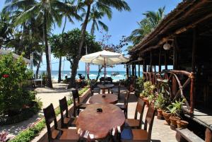 长滩岛Surfside Boracay Resort的一张桌子和椅子,配有遮阳伞和海滩