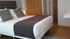 卢戈APARTAMENTOS PORTA NOVA的一间卧室配有一张带白色床单的大床
