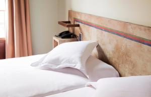 韦斯卡Hospedium Hotel Posada De La Luna的床上有白色枕头