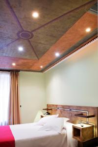 韦斯卡Hospedium Hotel Posada De La Luna的一间卧室设有两张床和天花板