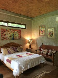 圣卡洛斯VillaHermosa B&B的卧室配有一张床,墙上挂有绘画作品