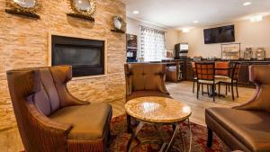 加利纳Best Western Galena Inn & Suites的酒吧配有皮椅、电视和桌子