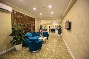 巴库Rusel Hotel的大堂设有蓝色的沙发、桌子和植物