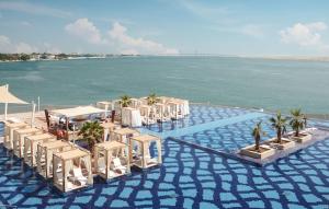阿布扎比Royal M Hotel Abu Dhabi by Gewan的海滩上的一组桌椅