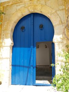 西迪·布·赛义德达法特马酒店的建筑中带有蓝色门的拱门