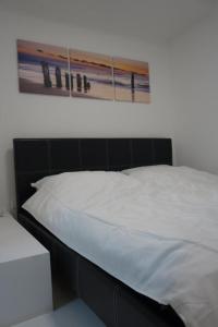 汉堡Kastanienallee 7的一张白色的床,墙上挂着一张照片