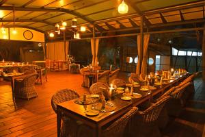 卡蒂马穆利洛Zambezi Mubala Lodge的餐厅的一张长桌,上面有蜡烛