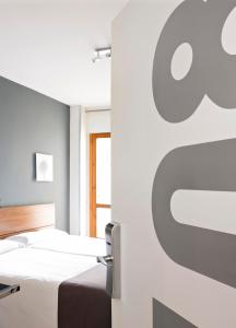 韦斯卡Hospedium Hostal Un Punto Chic的卧室配有两张床,墙上挂着苹果标志