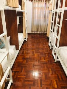 巴色Sanga Hostel的客房铺有木地板,配有双层床。