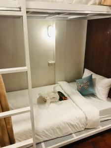 巴色Sanga Hostel的一张白色的双层床,上面有一只动物塞满了东西