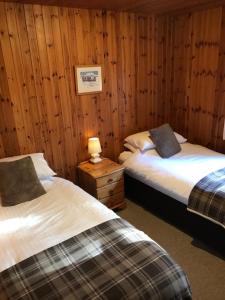 福里斯图尔洛赫伍德度假屋的木墙客房的两张床